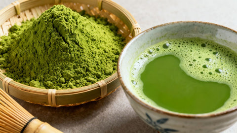 Matcha powder and a bowl of frothy green tea.